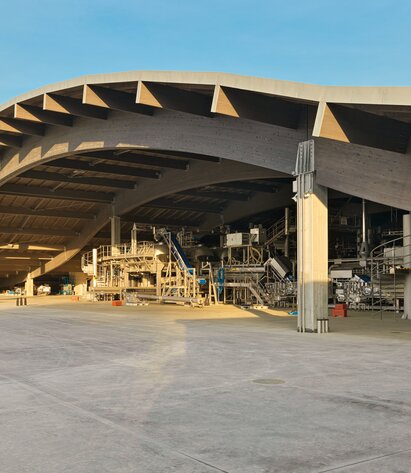 Eine große Halle mit einem geschwungenen Dach mit einer tragenden Struktur aus gebogenen Trägern aus Brettschichtholz | © Matteo Piazza