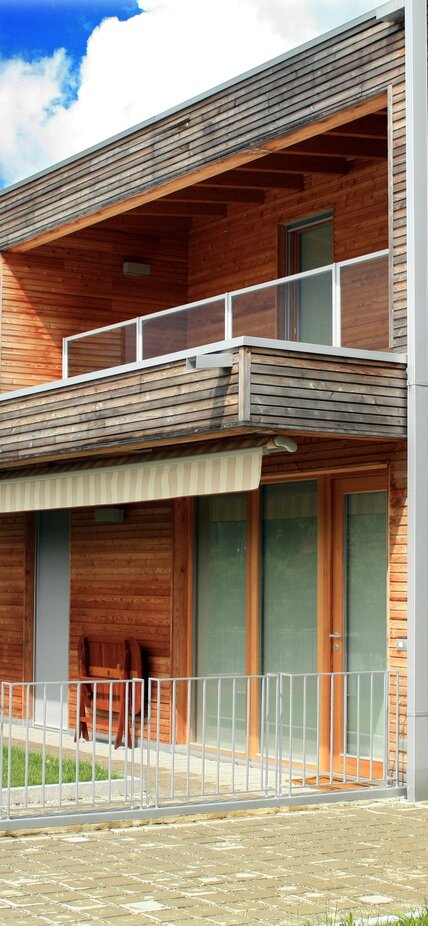 Reihenhäuser mit einer Fassade aus horizontal verlaufenden Holzleisten | © LignoAlp