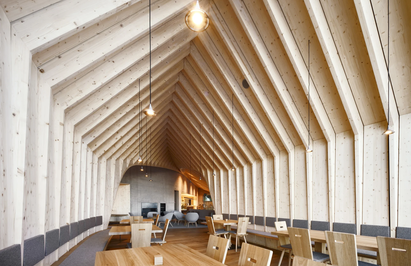 Innenansicht eines Restaurants. Das Dach besteht aus Portalen aus Fichtenholz in Sicht. | © © Oskar Da Riz